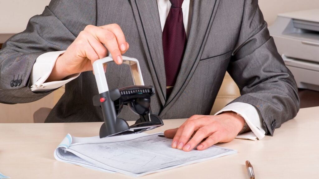 Photograph of a person stamping a document.