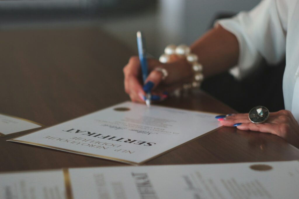 Photo of a woman signing a certificate.